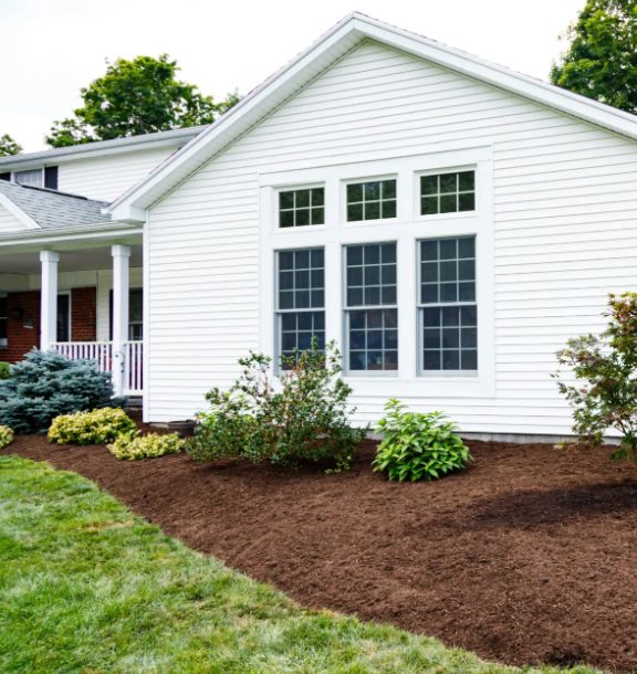 Freshly installed mulch bed along a home's foundation planting